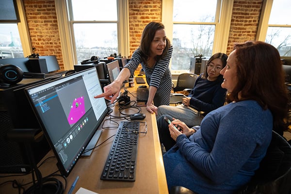 Professor teaching and pointing to computer