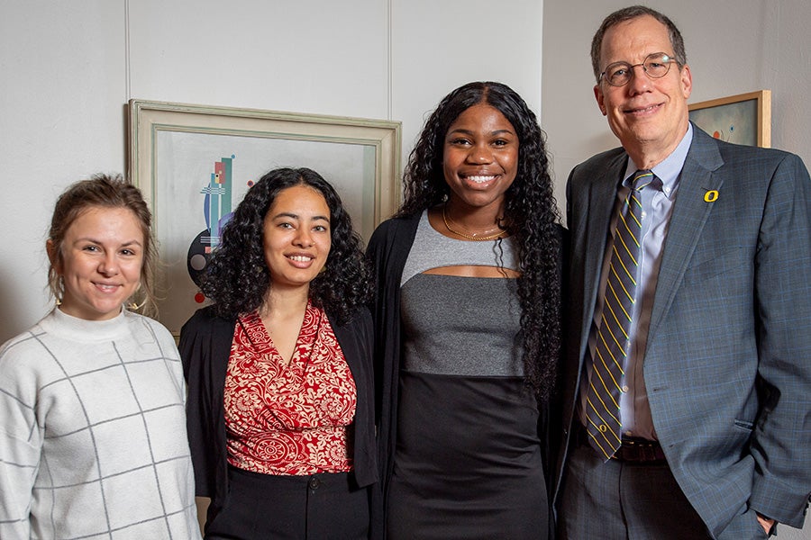 The UO President standing with the three 2023 Rhodes Scholars finalists.