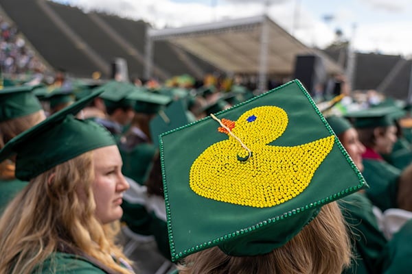 Students in Graduation Cap and Gown with decorative duck