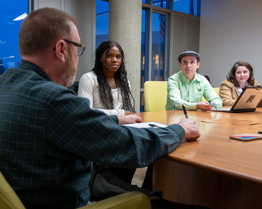 Students sitting at a table with Jeff Julum and Kevin Hatfield