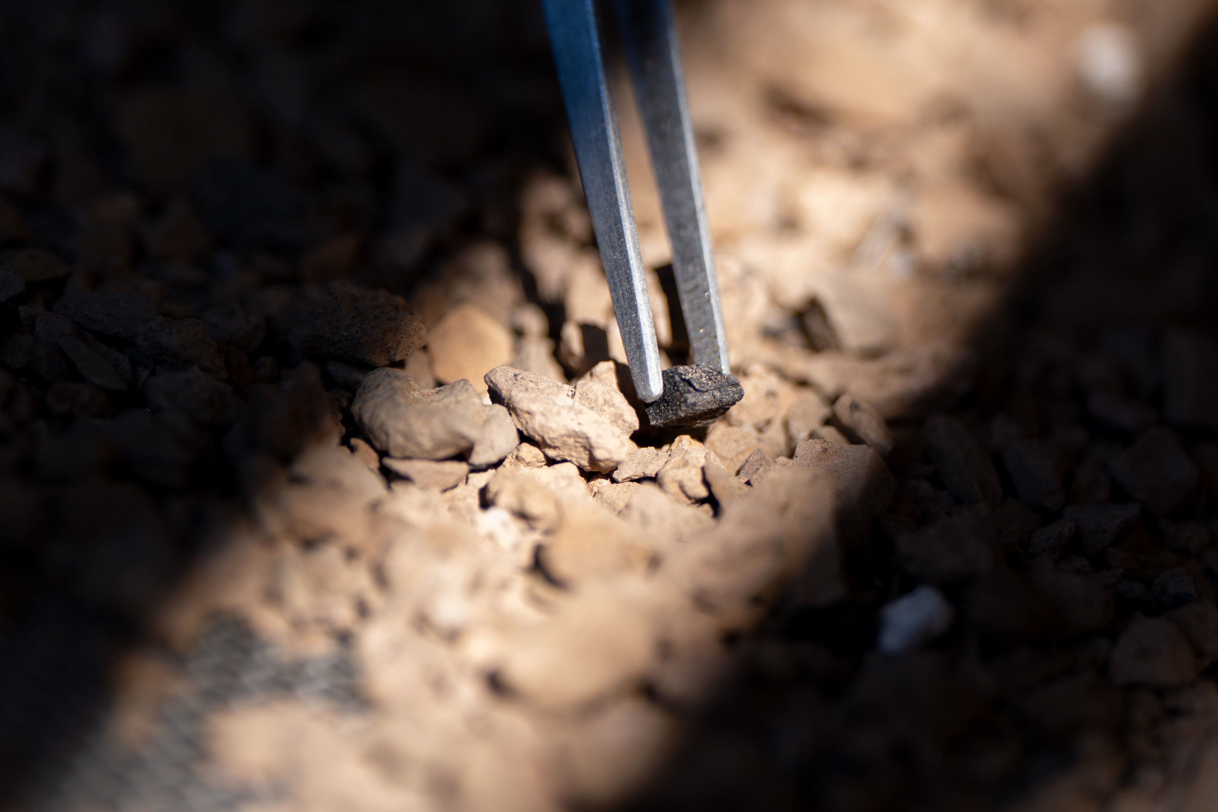 Closeup of a piece of stone with tweezers