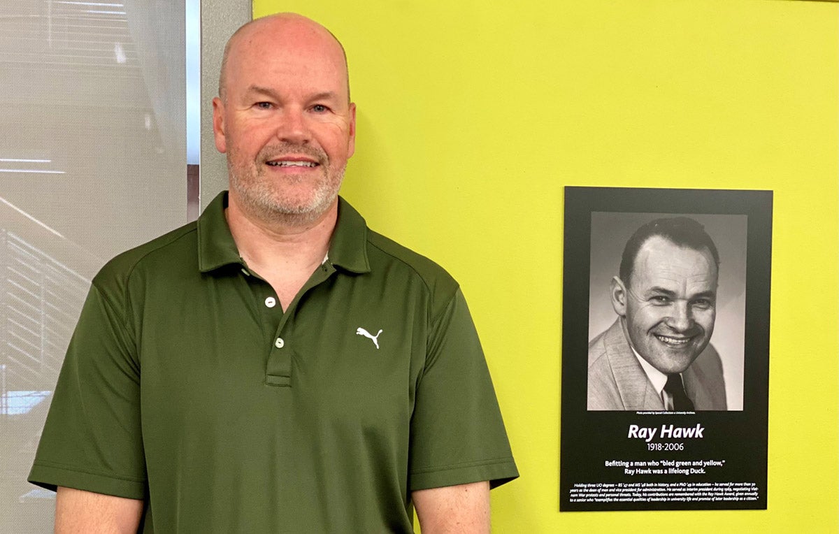 Ron Hawk standing in front of a picture of Ray Hawk