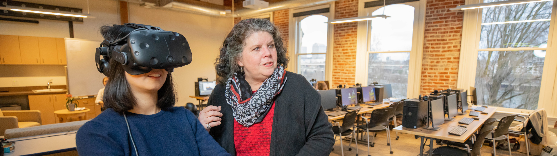 A student with VR headset and faculty member looking in the distance
