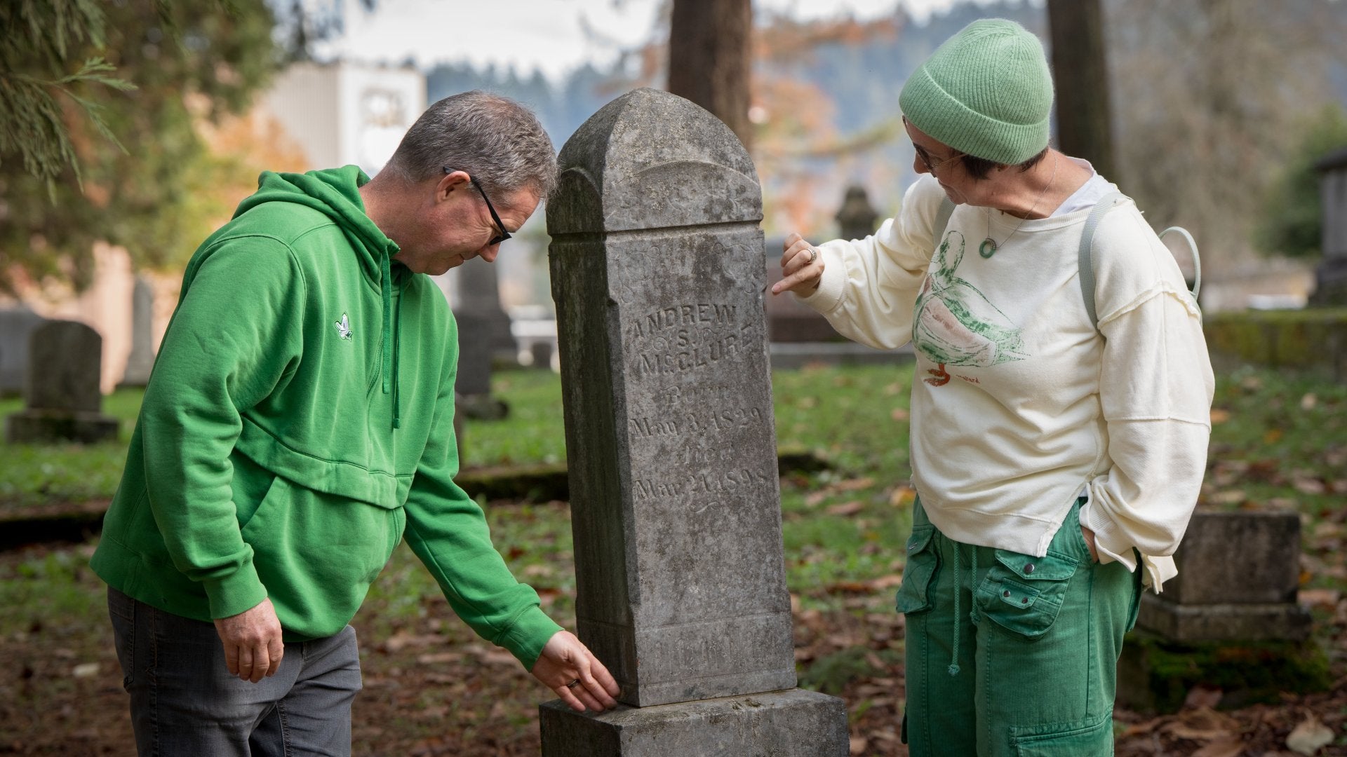 Kathleen and Brad McLeroy standing next to grave stone and inspecting it