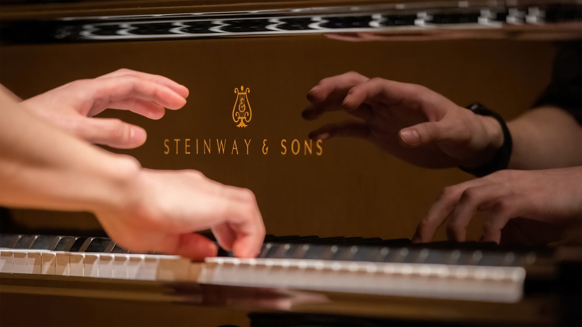 Hands playing a Steinway Piano with reflection 