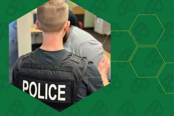 A student wearing a police vest participates in a mock fraud investigation during a simulated exercise.