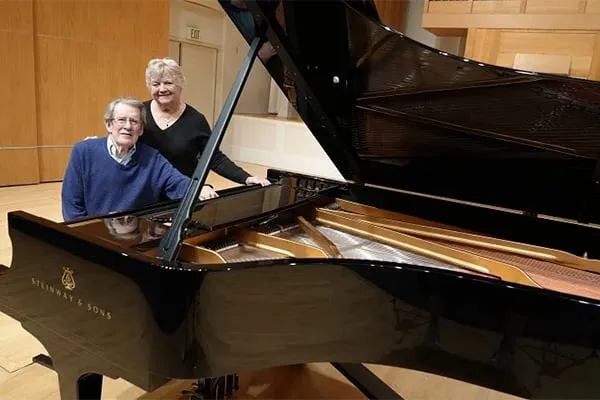 Dr. James and Marilyn Murdock sitting at piano