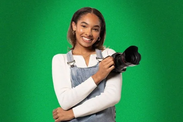 Student with a camera on a green background