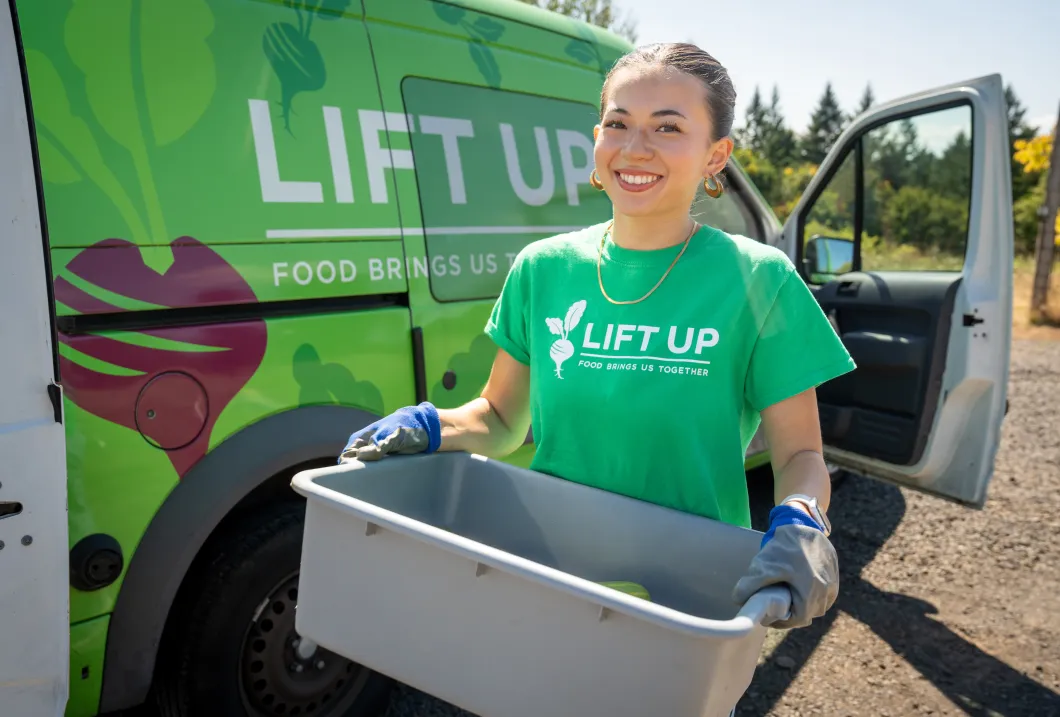 Sara Van Horn carries a tub of squash to a cargo van. 