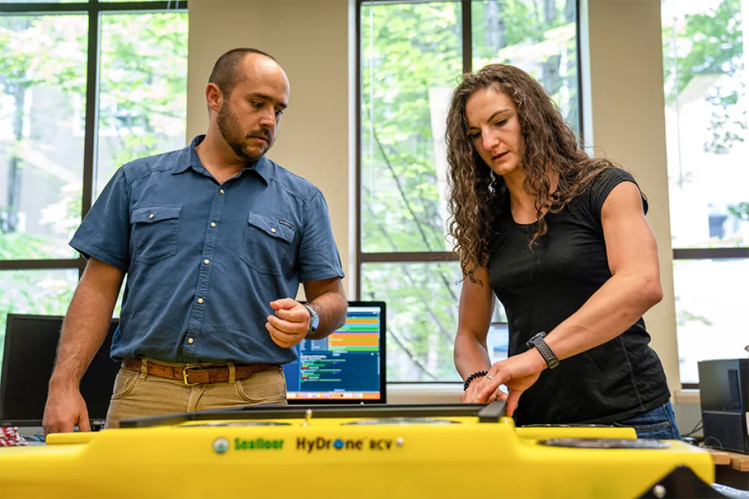 2 people working at a piece of research machinery