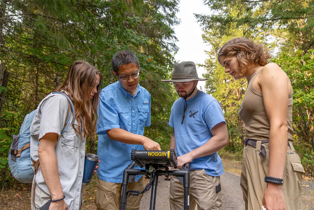 People gathered around a piece of technology