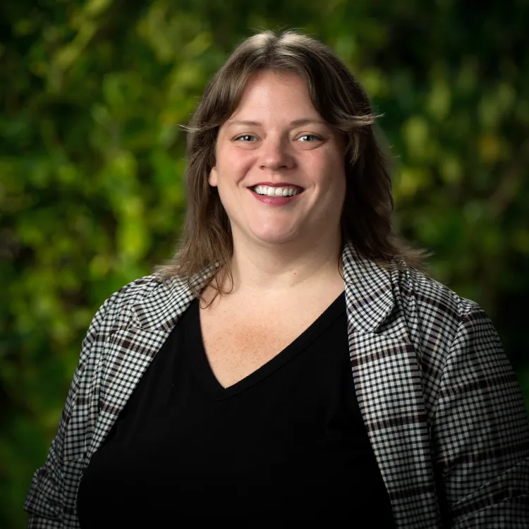 Kristyn Elton in front of a leafy green background