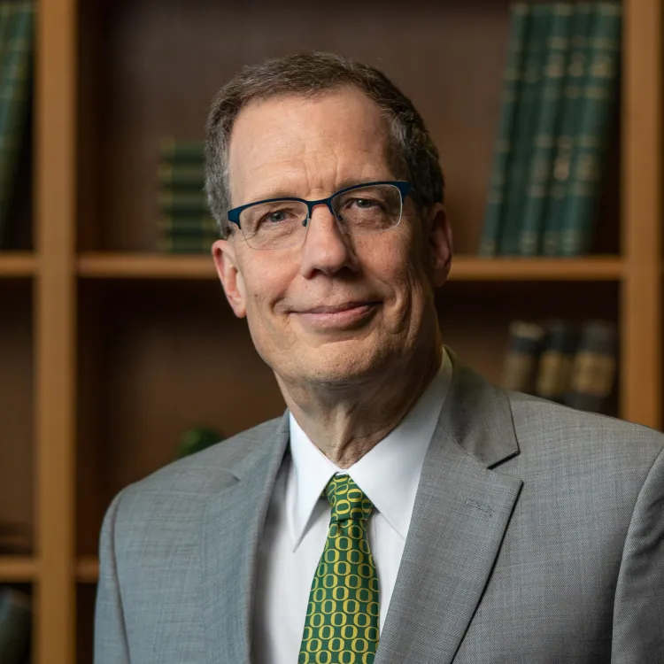 a smiling man in a suit and glasses