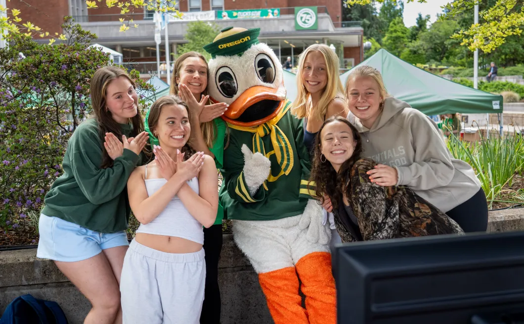 a group of smiling students pose with the Duck