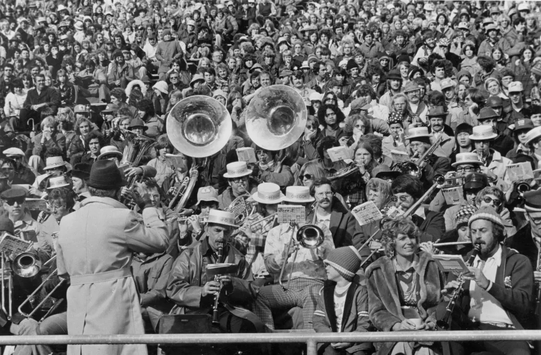 Old black and white photo of hundreds of people in a crowd with many holding some kind of instrument
