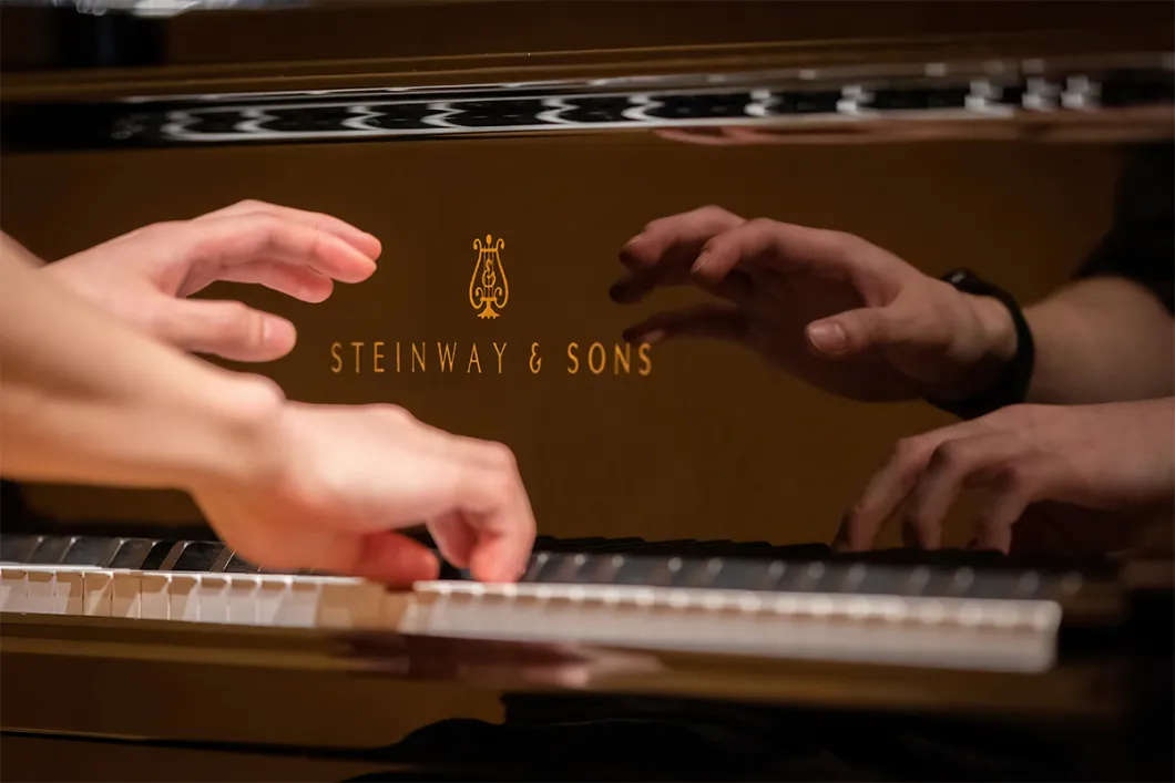 Hands playing a Steinway Piano with reflection 