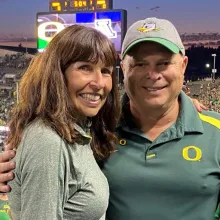 Alumni Sue and Todd in Duck gear in Autzen Stadium