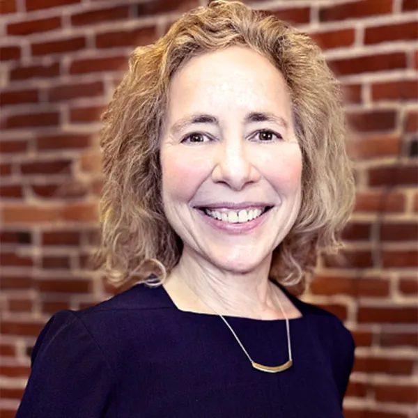 Smiling women standing in front of a brick wall 
