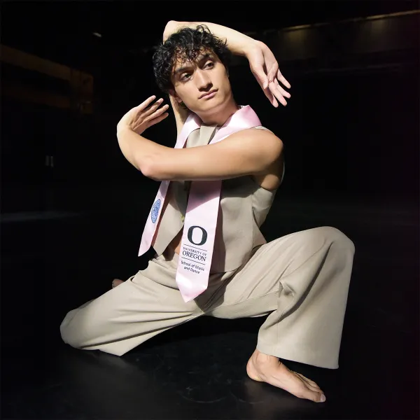 Caleb striking a dance pose on a darkened stage