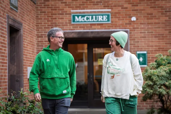 Kathleen and Brad McLeroy’s walking foward with McClure hall behind them