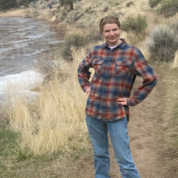 Student standing outside by a creek
