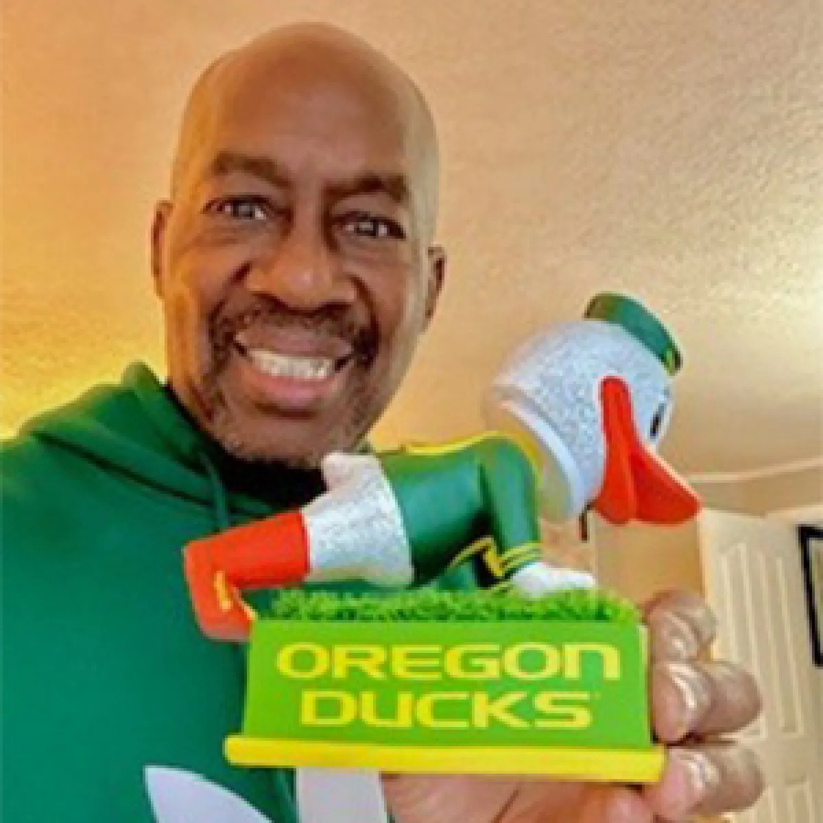 Man holding a figuring of the Oregon Duck doing push ups