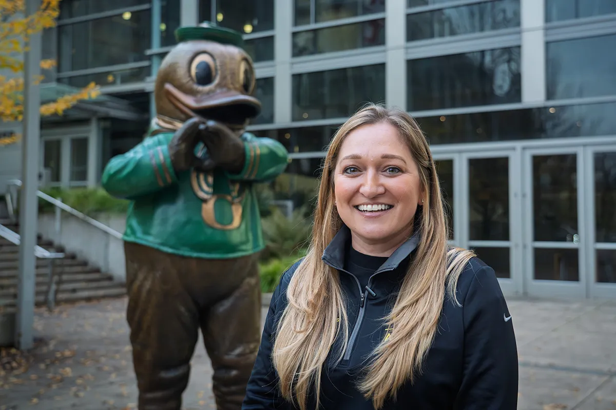 Kristen Bennett standing outside in front of the Bronze Duck at the Ford Alumni Center