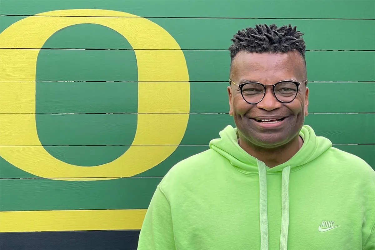 Wilson Smith standing in front of a green wall with a yellow O