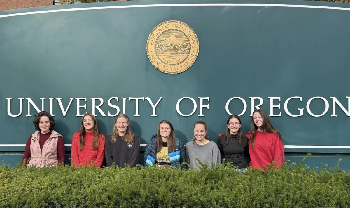 Women in Graduate Science standing in front of UO sign
